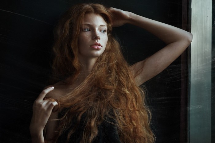 Redhead woman with freckles and long wavy hair