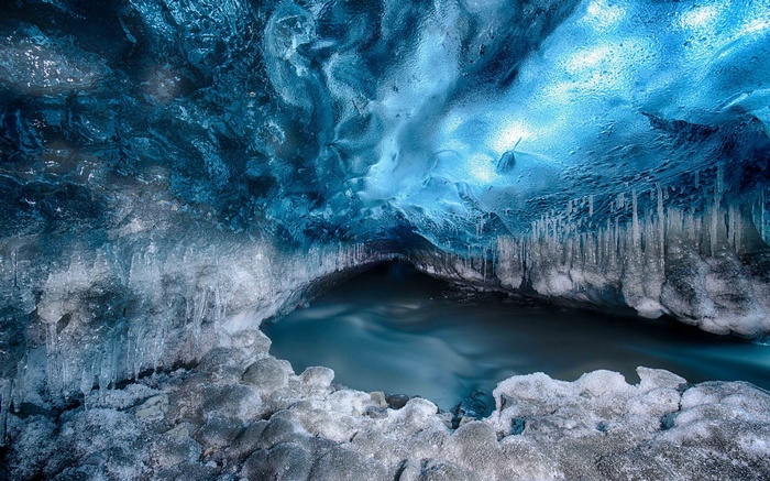 Ice cave with flowing water and icicles