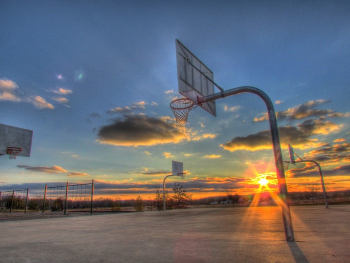 Basketball court at sunset with clouds