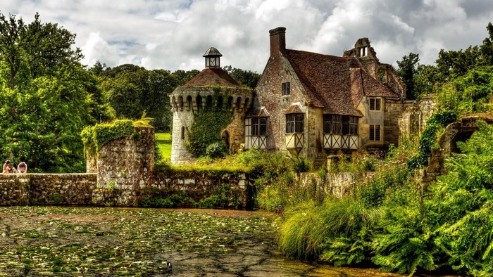 Scorney Castle in England with a pond and trees