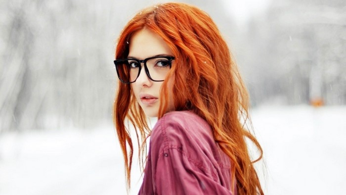 Redhead woman with glasses in snow