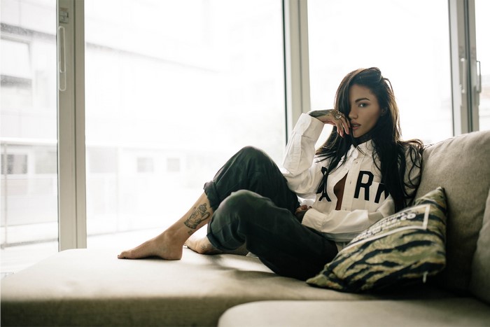 Woman sitting on a couch by the window