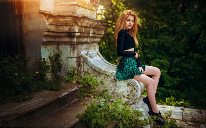 Woman with blonde hair sitting on stone stairs outdoors
