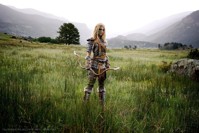 Cosplayer dressed as Skyrim character with bow in field
