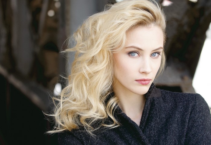 Sarah Gadon with blonde curly hair and blue eyes