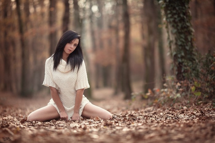 Woman in sweater dress in autumn forest