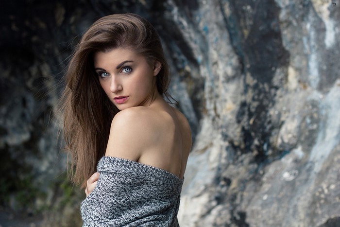 Woman with long brown hair and blue eyes wearing a sweater