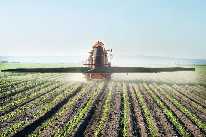 Agricultural sprayer in a young crop field