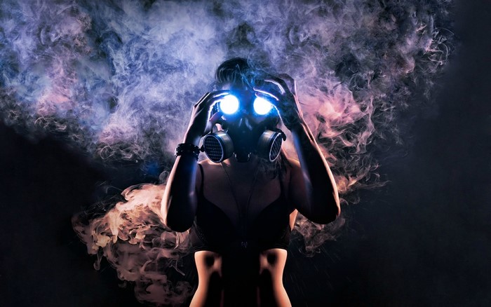 Woman in gas mask with glowing eyes and smoke