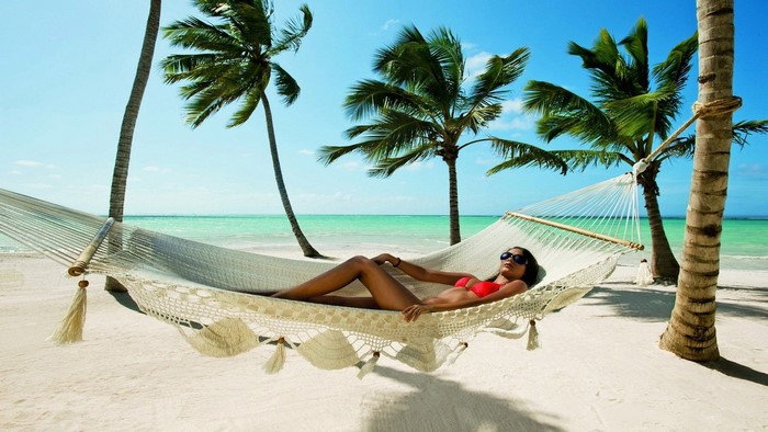 Woman relaxing in a hammock on a tropical beach