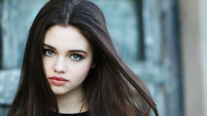 Young woman with long dark hair and blue eyes