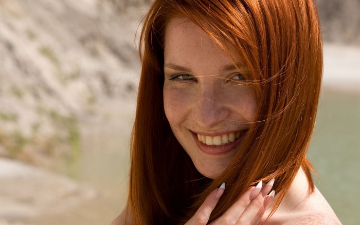 Redhead woman with freckles smiling outdoors