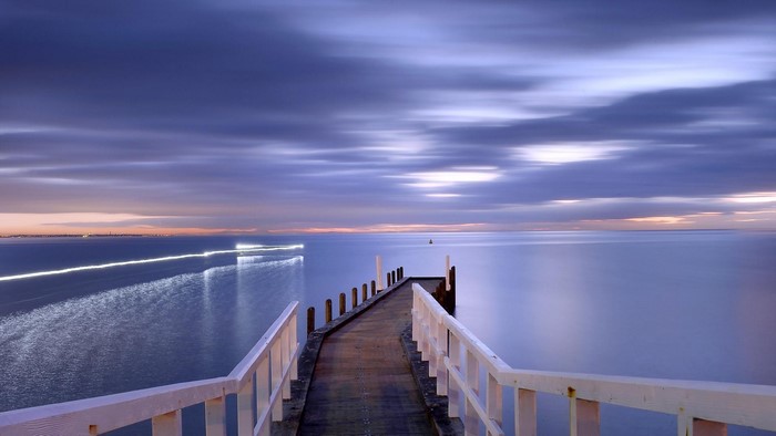Sunset over the ocean with a pier