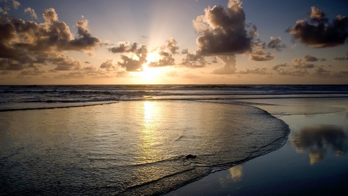 Beach at sunrise with crepuscular rays