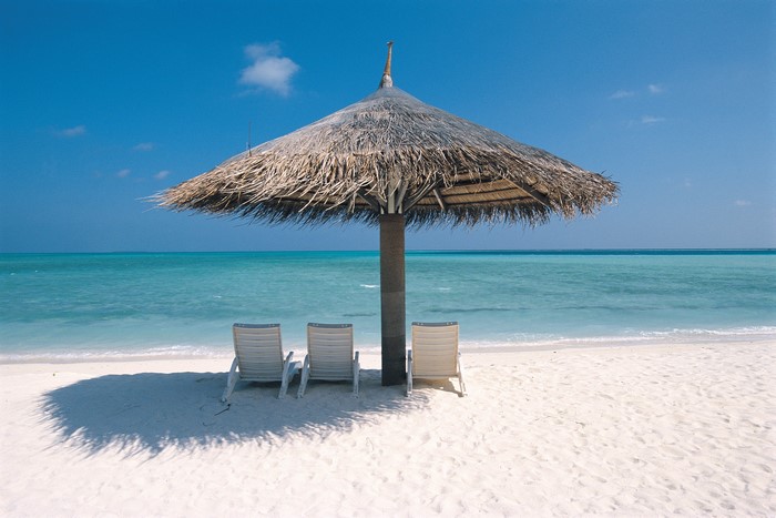 Serene Beach Scene with Chairs and Thatched Umbrella