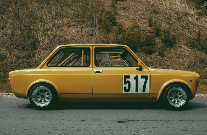 Yellow vintage Fiat 128 race car with number 517