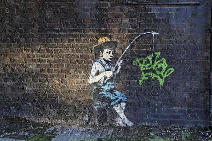 Banksy graffiti of a boy fishing