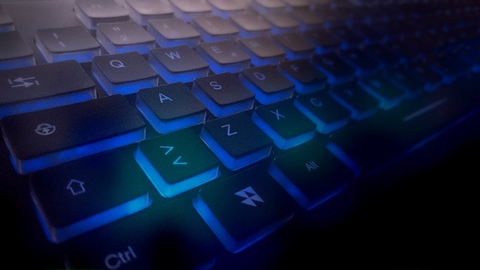 Close-up of a black keyboard with blue backlighting