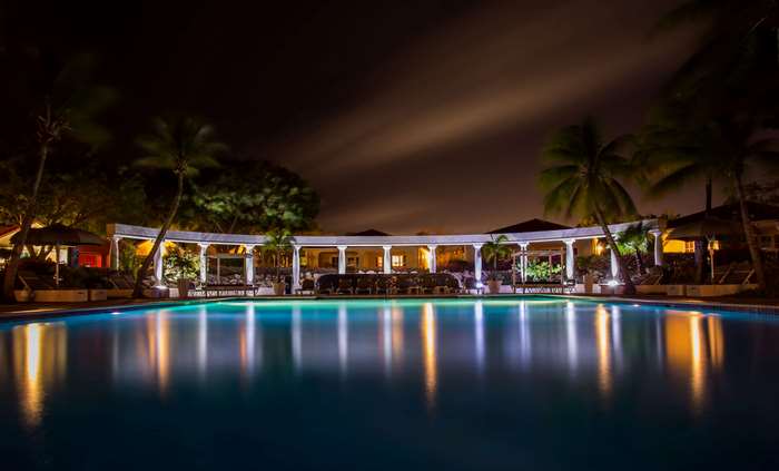 Luxury hotel pool at night with palm trees