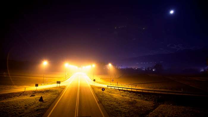Highway at night with street lamps and moon