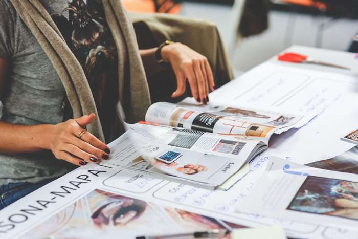 Woman reviewing documents and magazines at a table