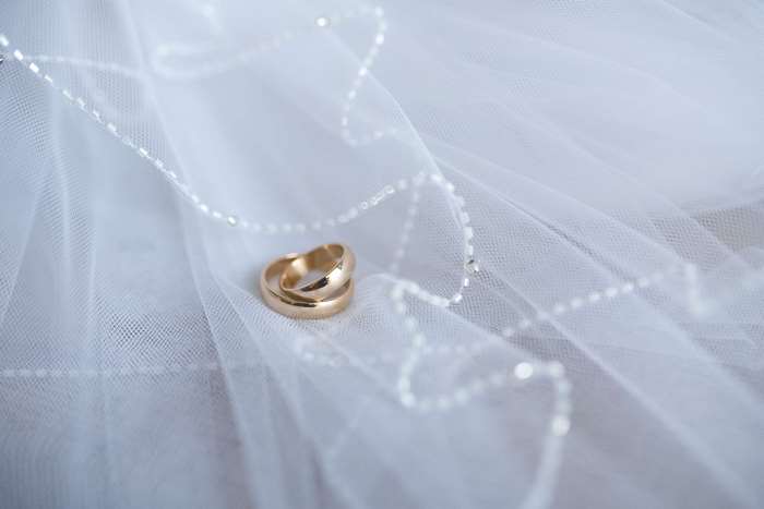 Wedding rings on a white veil 4K