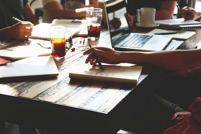 People working and studying at a wooden table
