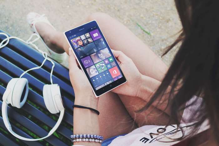 Woman holding a Nokia Windows Phone with headphones