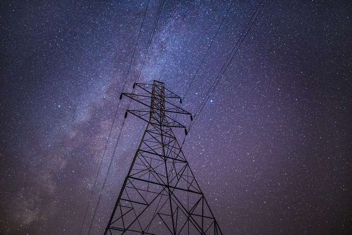 Electrical tower against a starry night sky