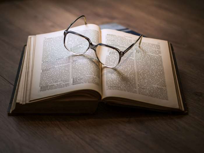 Vintage book with glasses on wooden table