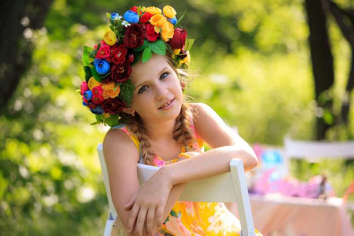 Girl with flower wreath in summer