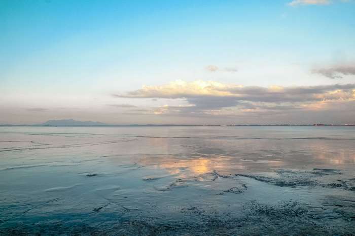 Calm sea and sky with distant mountains