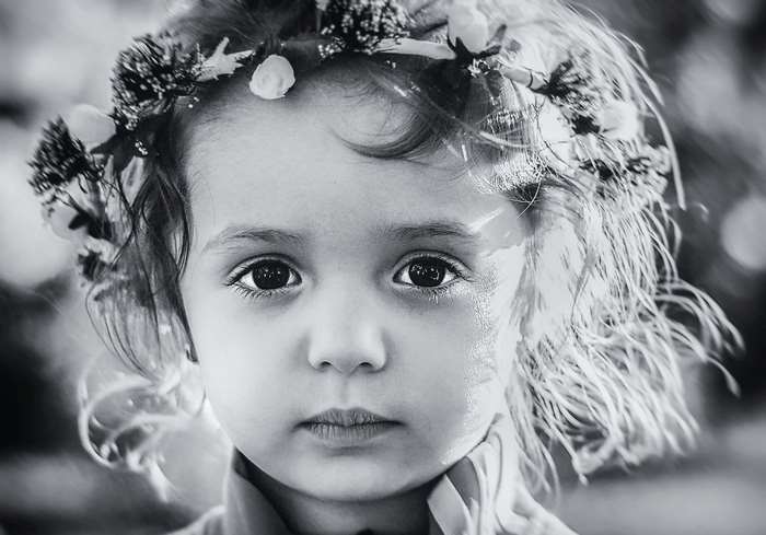 Black and white portrait of a young girl with a flower crown