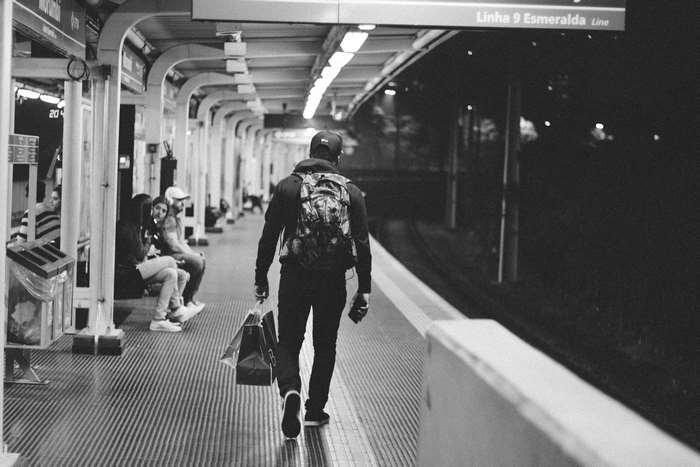 Man with backpack and shopping bags at train station