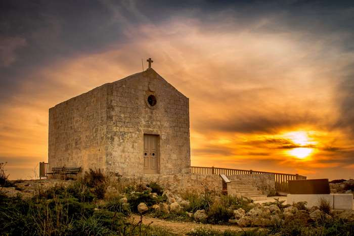 Chapel at sunset with cross and wooden fence