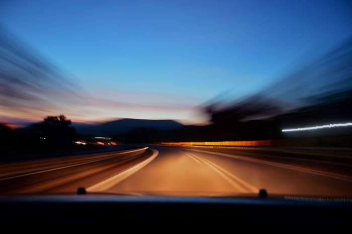 Blurred highway at dusk with car lights