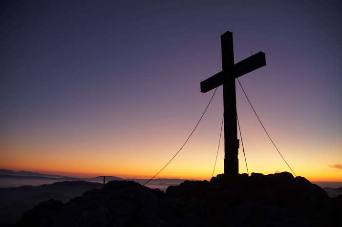 Silhouette of a summit cross at sunset 4K