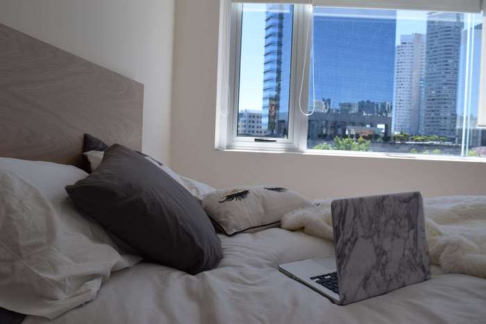 Bedroom with a laptop on the bed and city view