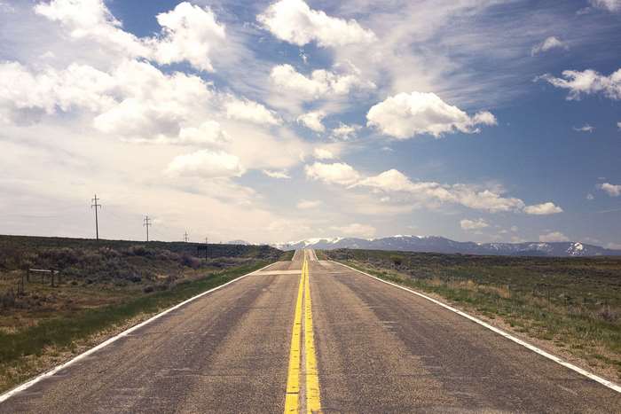 Endless highway through a vast landscape with mountains