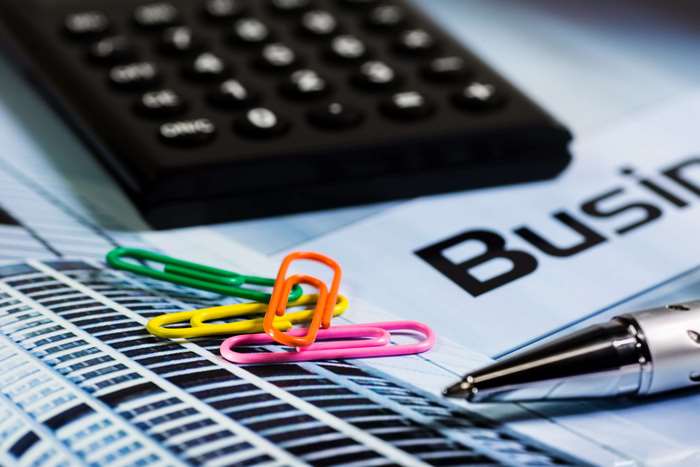 Calculator, paperclips, pen, and business document