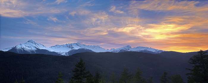Snow-capped mountains at sunset with colorful sky