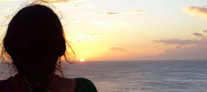 Silhouette of a woman watching the sunrise over the ocean