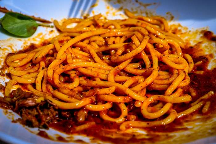 Spaghetti with meat sauce and a spinach leaf