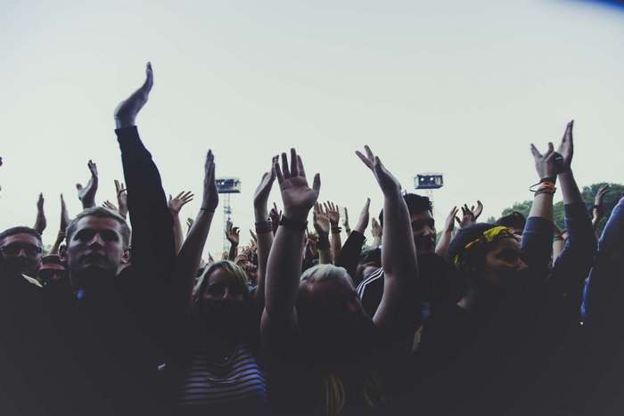 Crowd with hands raised at an outdoor music festival