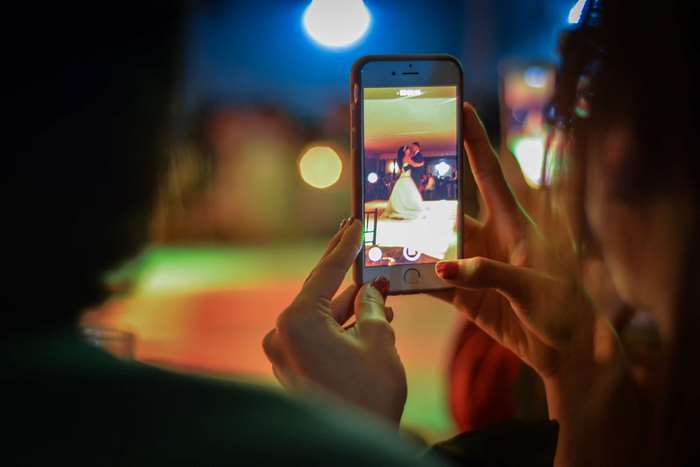 Woman recording wedding dance on iPhone