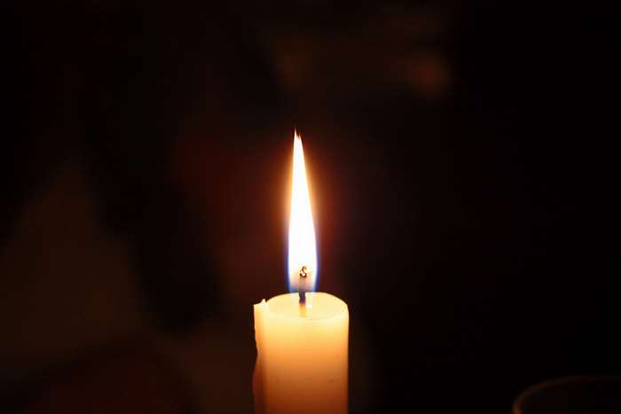 Close-up of a lit candle in the dark