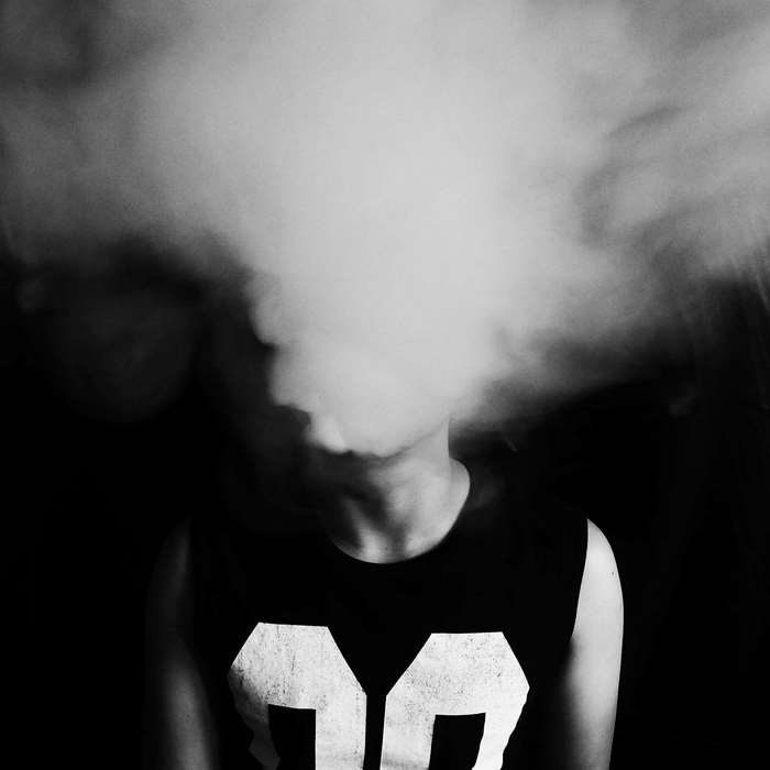 Person exhaling smoke in black and white