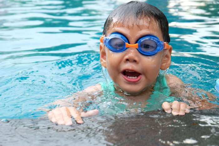 Young child wearing goggles in a swimming pool