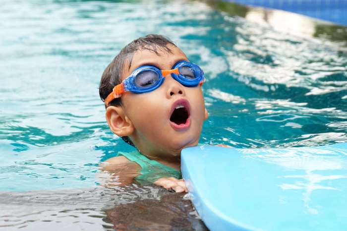 Young child wearing goggles in a swimming pool