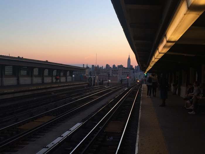 New York City skyline at sunset from a subway platform